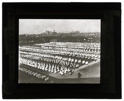 Horizontal, Black and White Photo of Hundreds of School Children Lined Up in Formation for Field Day Parade and Pageant. All the Girls in White Dresses and the Boys in White Shirts and Ties with Dark Pants by Unbekannt Unbekannt